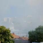 urban-landscape-city-with-smoke-from-burning-house-view-city-with-smog-fumes-from-building-fire-air-with-steam-flames-from-accident-with-dangerous-fire-town